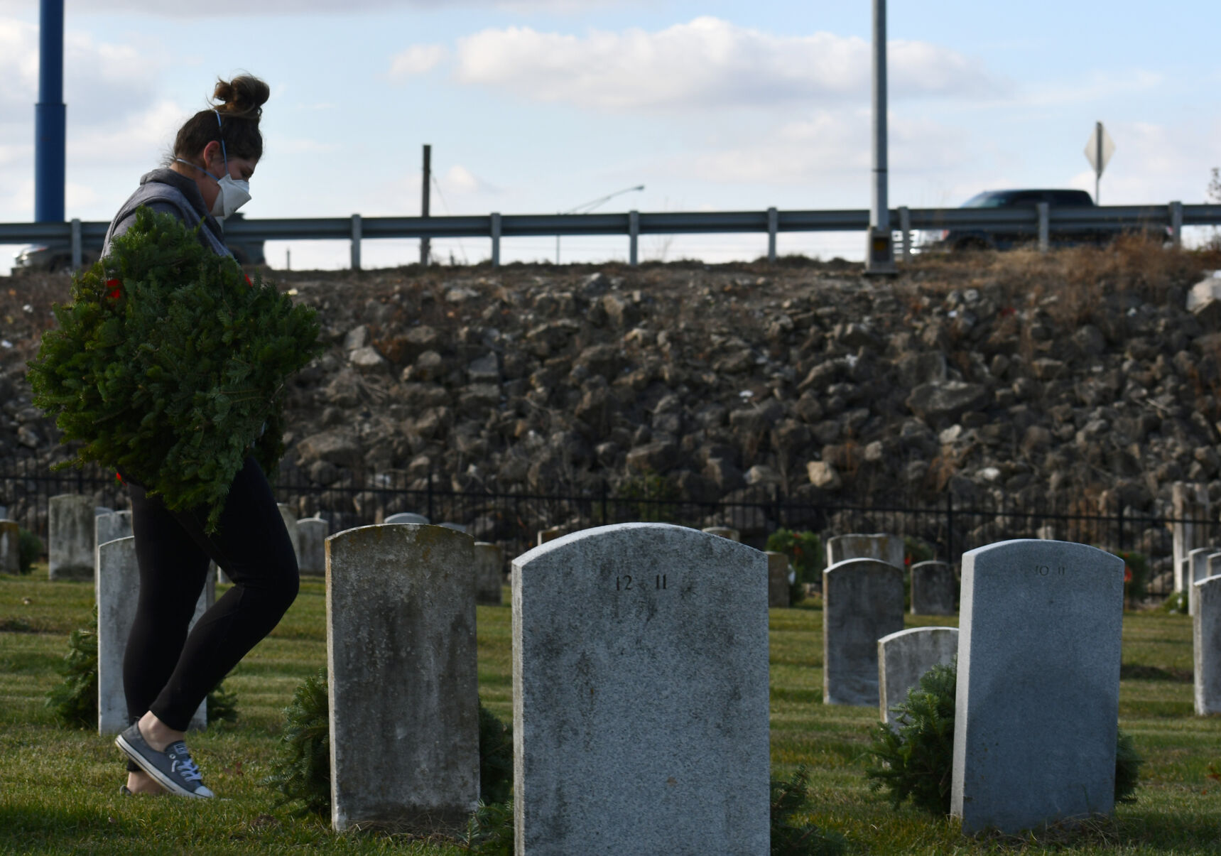 Heather Reeves carries wreath through the cemetery